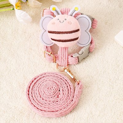 Harnais chien abeille rose avec ailes décoratives et laisse assortie enroulée sur fond clair