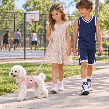 Harnais chien petite taille rose à motif ourson fillette et garçon promenant un caniche blanc devant un terrain de basket
