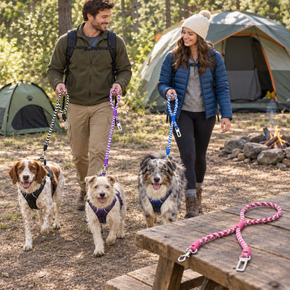 Laisse randonnée chien couple avec trois chiens attaches de couleurs différentes et attache rose sur la table au camping