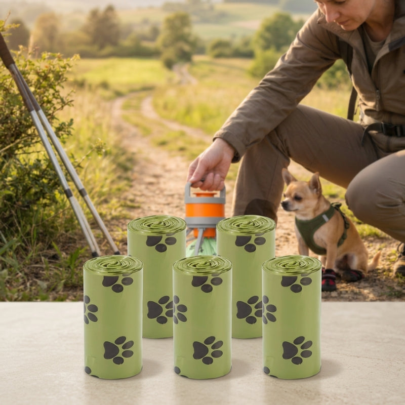 ramasse crotte pour chien cinq rouleaux de sacs verts à motifs de pattes avec une randonneuse et son chihuahua en arrière plan