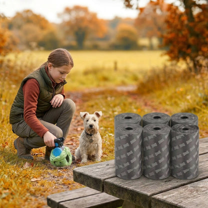 ramasse crotte pour chien six rouleaux gris à motifs de petits os sur une table de pique nique avec une fille et son terrier en automne
