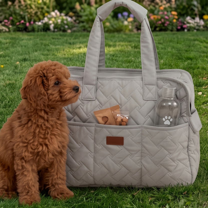 Sac de transport pour chien gris posé sur l’herbe avec un petit chien à gauche