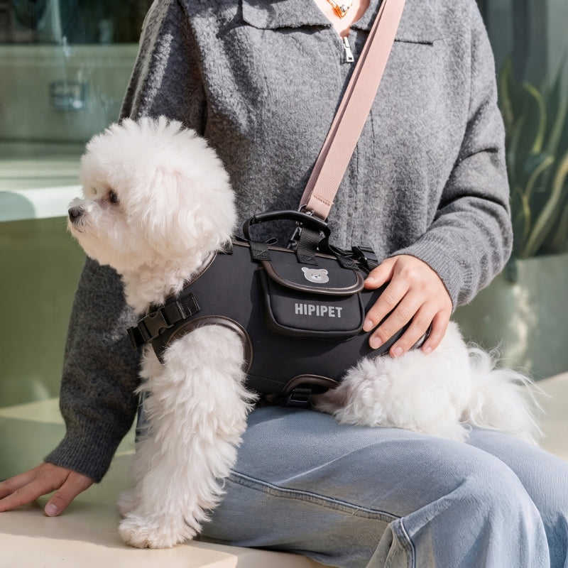 Sac de transport pour chiens noir porté par une femme avec un chien blanc